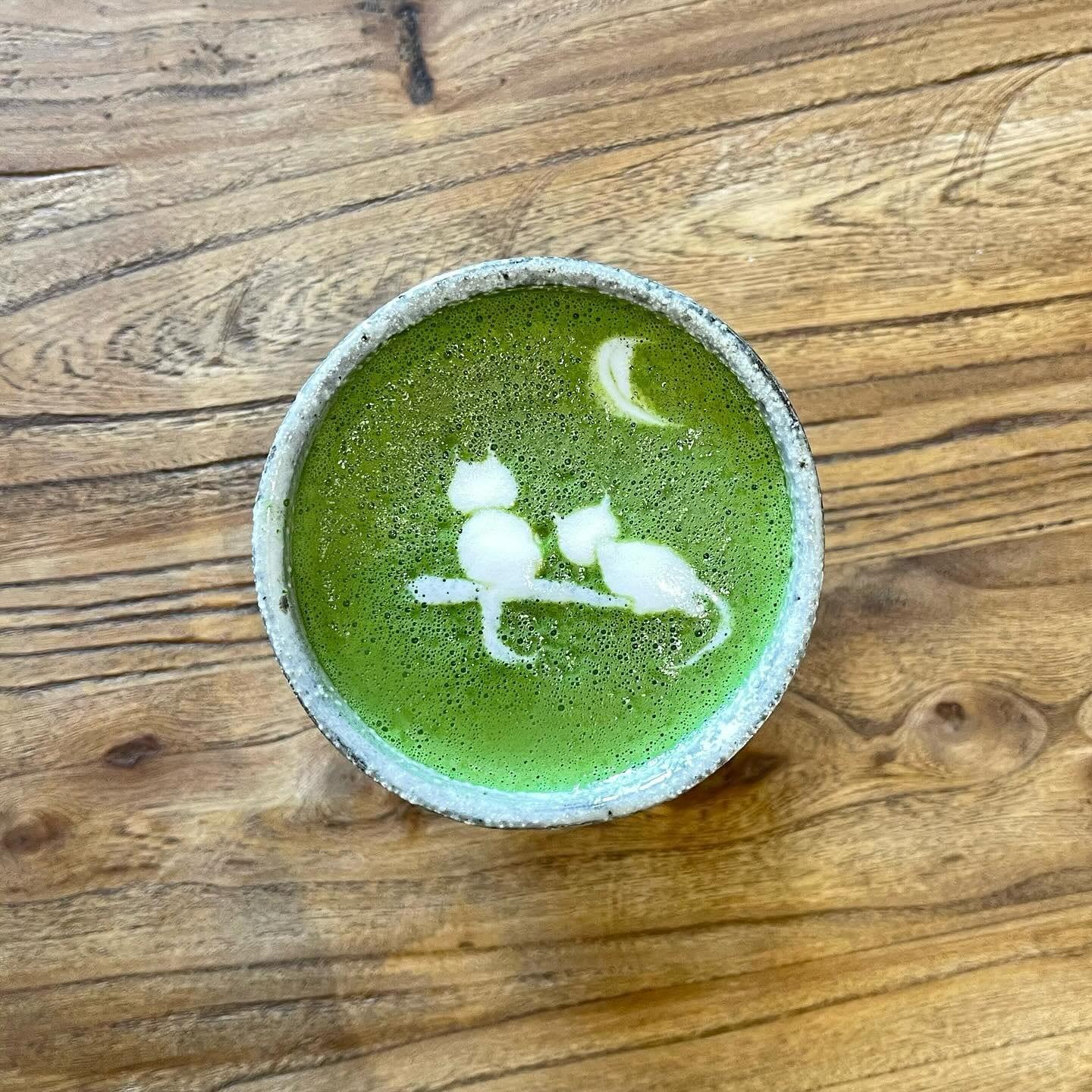 Matcha latte with two cats in the latte art