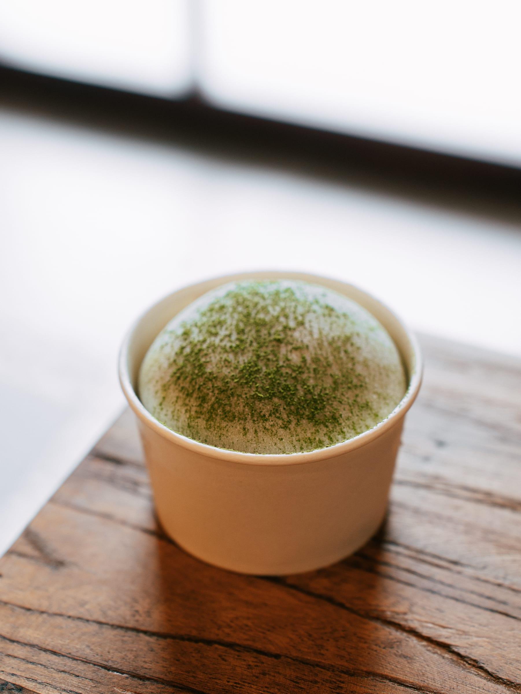 A cup of matcha ice cream, dusted with matcha
